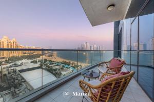 a balcony with two chairs and a view of the ocean at Manzil - Stylish 3BR in Palm w Private Beach & Sea View in Dubai