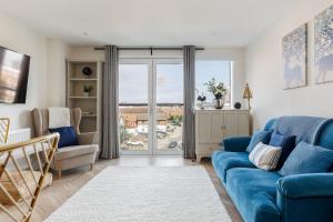 普爾的住宿－Rockpools，客厅设有蓝色的沙发和滑动玻璃门