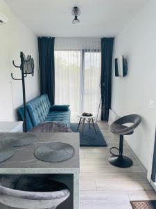 ein Wohnzimmer mit einem blauen Sofa und einem Tisch in der Unterkunft Tiny House by the forest 1 