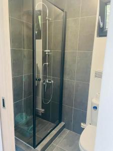 a shower with a glass door in a bathroom at Tiny House by the forest 1 