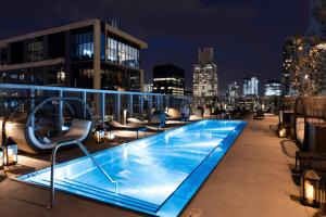a swimming pool on the roof of a building at night at Loop Studio w theater pool nr Millennium Park CHI-958 in Chicago