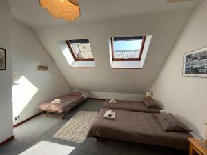 two beds in a attic room with two windows at Appartement Oz en Oisans in Oz