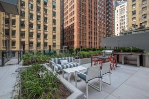 a rooftop patio with tables and chairs and buildings at Loop Studio w theater pool nr Millennium Park CHI-958 in Chicago