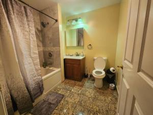 La salle de bains est pourvue de toilettes, d'un lavabo et d'une douche. dans l'établissement Classy 3 bed near NYC with view!, à Union City