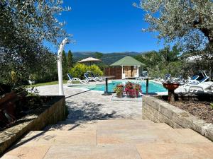 a pool with chairs and a table and a house at Country House La Montagnola in Valdobbiadene