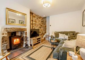 a living room with a couch and a fireplace at Ty Fin in Llanbedrog