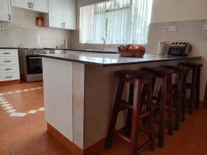a kitchen with a island with bar stools at Lantana Gardens B2 & B8 Apartment in Nairobi