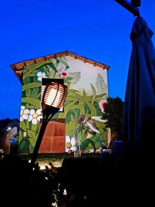 een gebouw met een schilderij erop met een lamp bij La locanda del cuore in Carrù
