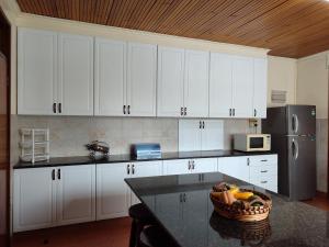 a kitchen with white cabinets and a bowl of fruit on a counter at Lantana Gardens B2 & B8 Apartment in Nairobi