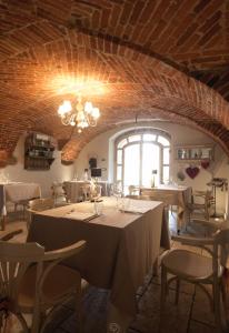 een eetkamer met tafels en stoelen en een plafond bij La locanda del cuore in Carrù