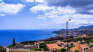 uma vista para a cidade e para o oceano com uma luz de rua em Casa Gina, with views to Funchal Bay em Funchal