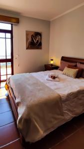 a bedroom with a large white bed with a woman on it at Casa Gina, with views to Funchal Bay in Funchal
