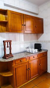 uma cozinha com armários de madeira e uma bancada em Casa Gina, with views to Funchal Bay em Funchal