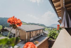 - un balcon offrant une vue sur une maison fleurie dans l'établissement Ragitt Stodl Ferienwohnungen, à Vols am Schlern