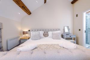 a white bedroom with a large bed with white pillows at Unique 2-bed barn in Beeston by 53 Degrees Property, ideal for Families & Friends, Great Location - Sleeps 4 in Beeston