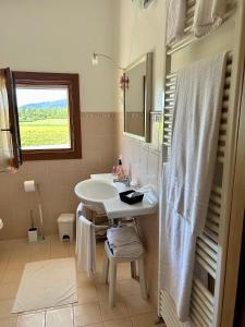 Baño blanco con lavabo y espejo en Country House La Montagnola, en Valdobbiadene