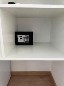 a black and white clock on a white shelf at Maison Dante in Naples
