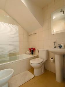 a white bathroom with a toilet and a sink at Condado de Alhama, Jardin 7 in Alhama de Murcia