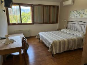 1 dormitorio con 2 camas, mesa y escritorio en Country House La Montagnola, en Valdobbiadene