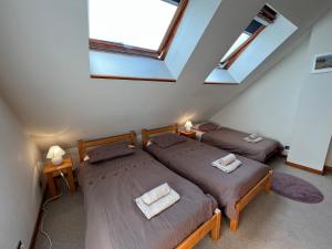 two beds in a attic room with a skylight at Appartement Oz Village in Oz