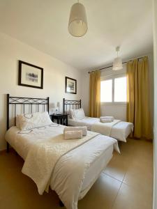 a bedroom with three beds and a window at Condado de Alhama, Jardin 7 in Alhama de Murcia