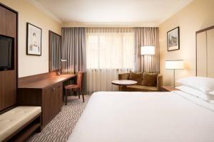 a hotel room with a bed and a desk at Sheraton Zagreb Hotel in Zagreb