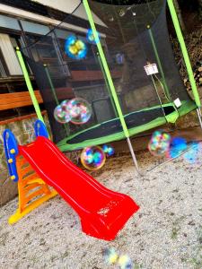 a playground with a red slide and balls at Pensiunea Don Sergio in Predeal