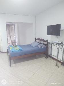 a small bed in a room with a tv at Apartamento amplo pé na areia - Itapema 180m da Praia in Itapema