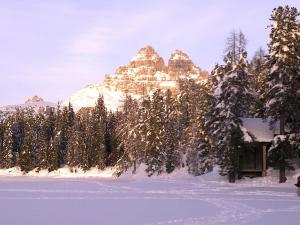 uma cabana na neve em frente a uma montanha em Margiolà em Calalzo