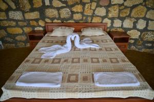 dois cisnes estão sentados numa cama com toalhas em Комплекс Замъка 