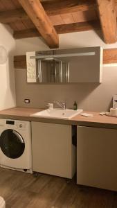 een keuken met een wastafel en een wasmachine bij La locanda del cuore in Carrù