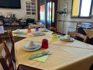 a table with plates and utensils on top of it at Country House La Montagnola in Valdobbiadene