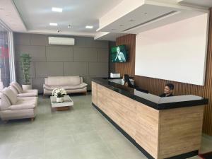 a man sitting at a reception desk in a lobby at Hotel Seven in Goiânia