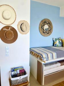 a bedroom with a bed with hats on the wall at Elounda Beach View House in Epáno Eloúnda +12 photos