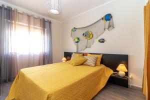 una camera con letto giallo e un pallone da basket sul muro di Apartment Breeze located in the heart of Carvoeiro a Carvoeiro