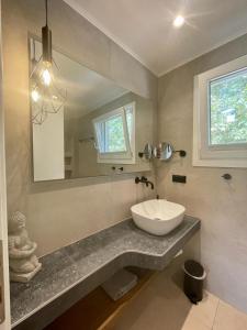 La salle de bains est pourvue d'un lavabo et d'un miroir. dans l'établissement Casa O' - Moderne Villa mit großer Terrasse und privatem Swimmingpool, à Skala Potamias