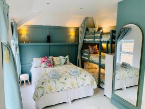 a bedroom with two bunk beds and a mirror at The Coach House in Matlock