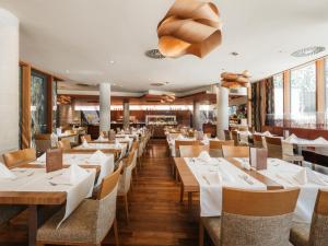 una sala da pranzo con tavoli e sedie in legno di Hotel Kristal - Terme Krka a Dolenjske Toplice