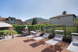 - un ensemble de chaises et de tables sur une terrasse dans l'établissement Agriturismo il Borgo - Rosmarino, à Villanova dʼAlbenga