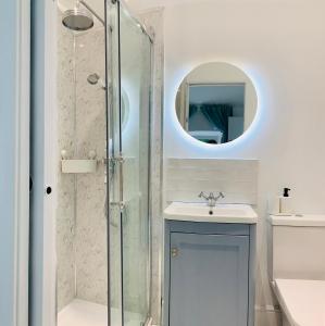 a bathroom with a shower and a sink and a mirror at The Coach House in Matlock