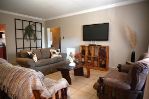 a living room with couches and a flat screen tv at Summersun Village in Parys