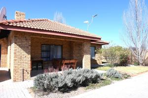 a small brick house with a table in front of it at Summersun Village in Parys