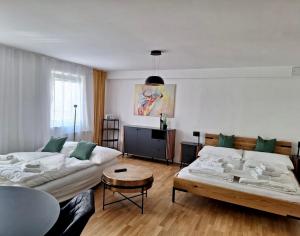 una sala de estar con 2 sofás blancos y una mesa. en Ruhiges Apartment mit Terrasse im Zentrum St. Pölten en Sankt Pölten