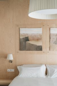 Hotel Santa Ana Tudela في توذيلا: غرفة نوم بسرير ودهان على الحائط