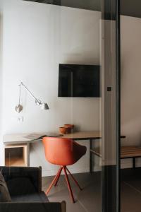 a living room with a desk and a red chair at Hotel Santa Ana Tudela in Tudela