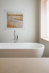 a white bath tub in a bathroom with a painting at Hotel Santa Ana Tudela in Tudela