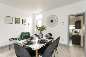 un comedor blanco con mesa y sillas en Wainscott Terrace - Spacious 2 double bedroom house with on-street parking short walk away from seafront, en Portsmouth