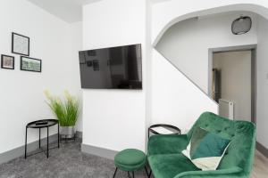 una sala de estar con una silla verde y una mesa en Wainscott Terrace - Spacious 2 double bedroom house with on-street parking short walk away from seafront, en Portsmouth