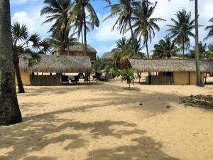 a resort with palm trees and a building on the beach at Barra Dica - CAMPING in Inhambane