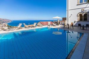 a swimming pool with chairs and a view of the ocean at Villino rosso in Taormina